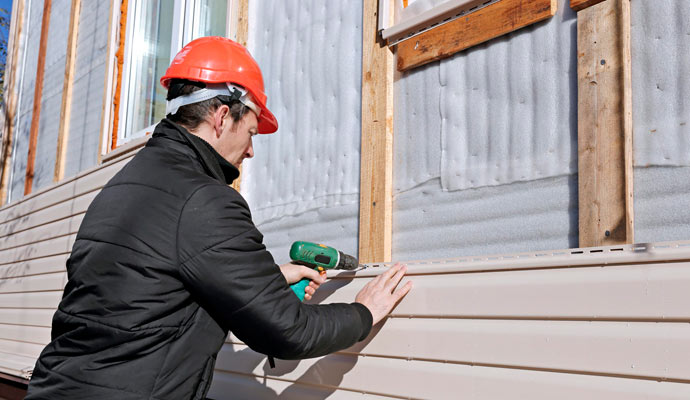 a-man-wears-red-helmet-repair-siding