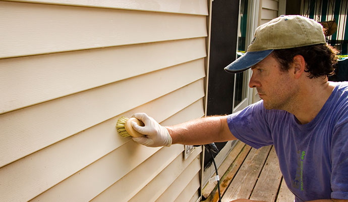 worker-cleaning-siding-